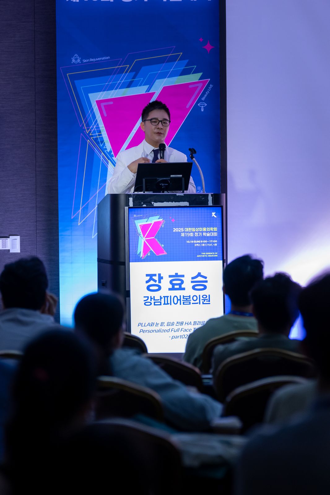 แท่นบรรยายในการประชุมครั้งที่ 18 พร้อมป้ายชื่อ Jang Hyoseung · Gangnam Pieobom Clinic